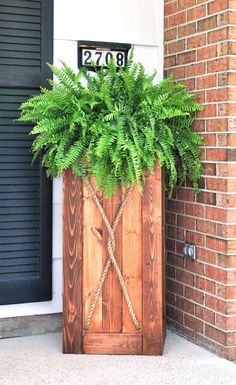 a potted plant sitting on top of a wooden box next to a brick building