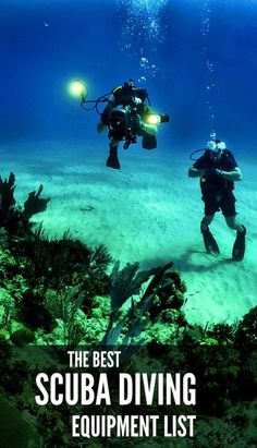 two scuba divers in the ocean with their lights on and underwater plants growing out of the water