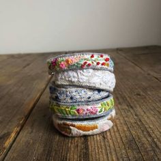 a stack of bracelets sitting on top of a wooden table