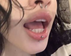 a woman with piercings on her nose is smiling