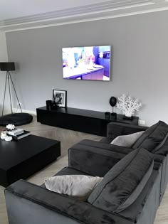 a living room filled with furniture and a flat screen tv mounted to the side of a wall