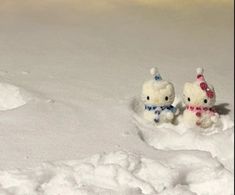 two stuffed animals are sitting in the snow