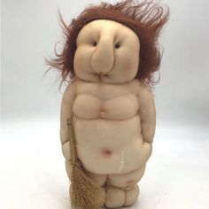 a ceramic sculpture of a naked man with long hair and a broom in his hand