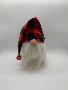 a red and black plaid gnome hat with white fur on it's head is shown