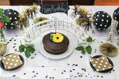 a table topped with a chocolate cake covered in frosting and flowers on top of it