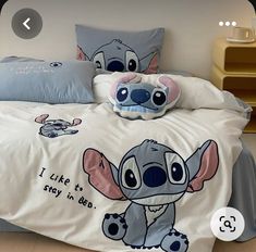 a bed with two pillows on top of it and a stuffed animal in the middle