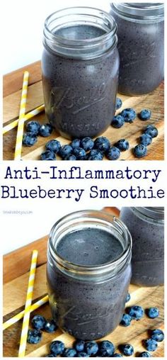 two jars filled with blueberry smoothie sitting on top of a wooden cutting board