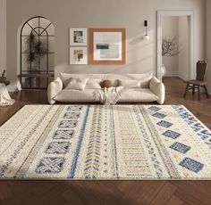 a living room filled with furniture and a rug on top of a hard wood floor