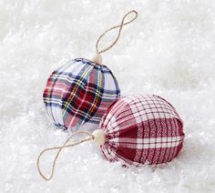 two plaid hats hanging from strings on snow