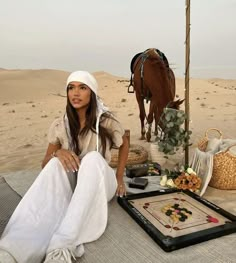 a woman sitting on top of a bed next to a horse