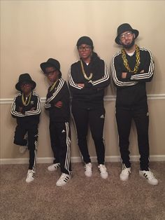 three young men standing next to each other in front of a wall