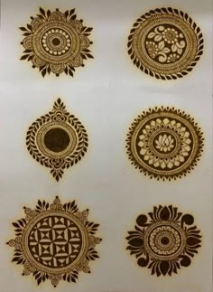 four different designs on the back of a white sheet with gold foil and black ink