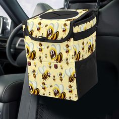 a yellow and black bag with bees on it sitting in the back seat of a car