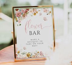 a flower bar sign sitting on top of a wooden table