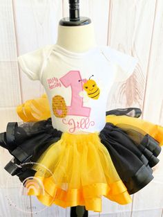 Bumble Bee Tutu Outfit, Bee Birthday Shirt, Bumble Bee Birthday Tutu Outfit, Bee Birthday party outfit, Ribbon Trim Tutu Outfit PROCESSING TIME IS 3-5 DAYS NOT INCLUDING SHIPPING. This personalized bumble bee birthday shirt is a great choice for your next bee theme birthday party outfit. This pink, yellow and black birthday outfit features the birthday number of your choice along with a super cute bumble bee embroidered onto it. This bee birthday shirt is perfect for young girls. Your little one Bee Theme Birthday Party, Black Birthday Outfit, Bee Birthday Theme, Bumble Bee Birthday, Ribbon Trim Tutu, Bee Birthday Party, Birthday Party Outfit, Birthday Tutu Outfit, Black Birthday