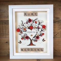 a scrabbled wedding tree with red flowers and words written on it in white frame