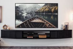 there is a boat on the water in this living room wall art print that has been hung above a black entertainment center