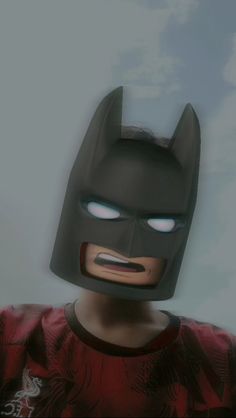 the lego batman mask has glowing eyes and is wearing a red shirt with an eagle on it