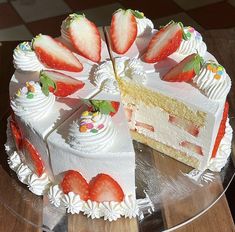 there is a cake with white frosting and strawberries on the top, cut into slices