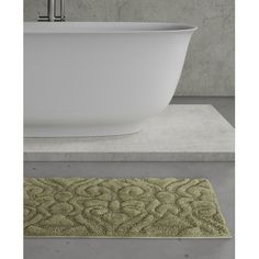 a bath tub sitting next to a bathroom rug