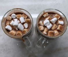 two cups filled with hot chocolate and marshmallows