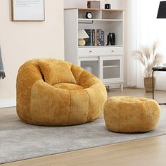 a living room with a yellow bean chair and footstool next to a book shelf