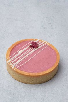 a pink dessert with white icing sitting on top of a table