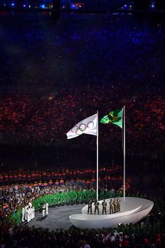 the olympic flag is raised at the opening ceremony