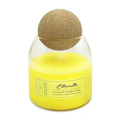 a yellow candle with a brown ball in the top and on it's lid