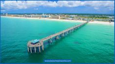 an aerial view of a long pier in the middle of the ocean with buildings on both sides