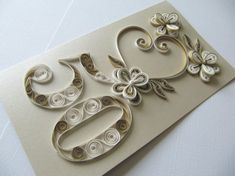 an intricately designed greeting card with flowers and swirls on the front, in white paper