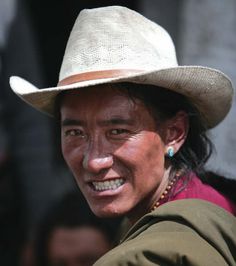 a man wearing a hat and smiling for the camera