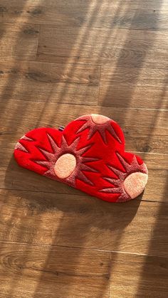 a red stuffed animal laying on top of a wooden floor