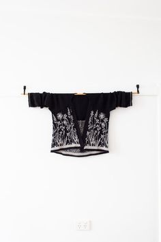 a black and white top hanging on a wall