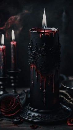 three candles are lit in the dark with blood dripping from them and roses on the table