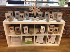 a shelf filled with pictures and cards on top of a wooden floor