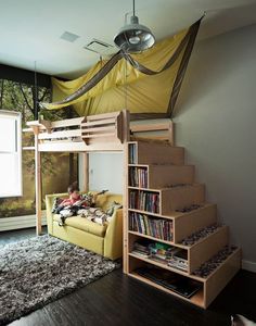 a loft bed with stairs and bookshelf in the corner next to a couch