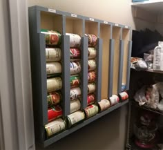 an organized spice rack in the corner of a room with spices and cans on it