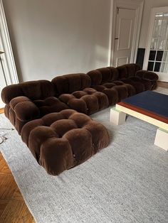 a large sectional couch sitting on top of a rug in a living room next to a coffee table