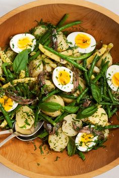 a wooden bowl filled with green beans and eggs