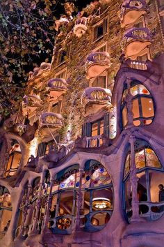 an unusual building with many windows and balconies on the side of it at night