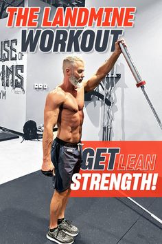 a man standing on top of a gym floor holding a bar