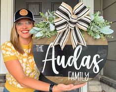 a woman holding a sign that says the auda's family