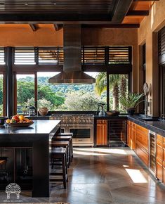 a large kitchen with an island counter top and wooden cabinets in front of the window