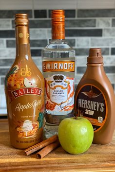 apples, cinnamon sticks, and bottles of alcohol on a counter