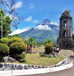 people are walking around in front of a mountain