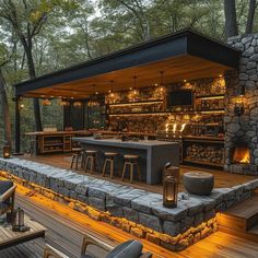 an outdoor bar is lit up at night with lights on the tables and stools