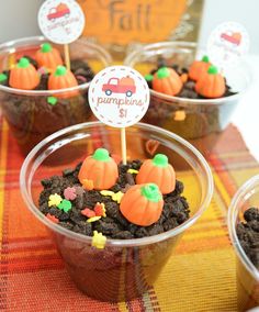 cupcakes in plastic cups decorated with pumpkins and dirt on a checkered tablecloth