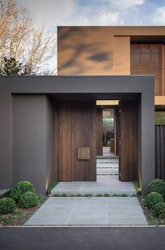 an entrance to a modern home with wood and metal sidings on the outside wall