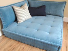 a blue couch sitting on top of a hard wood floor